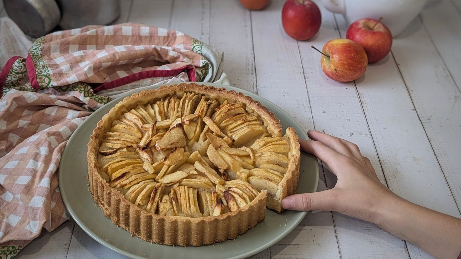 tarte aux pommes à la compote maison, avec un main qui attrape une part